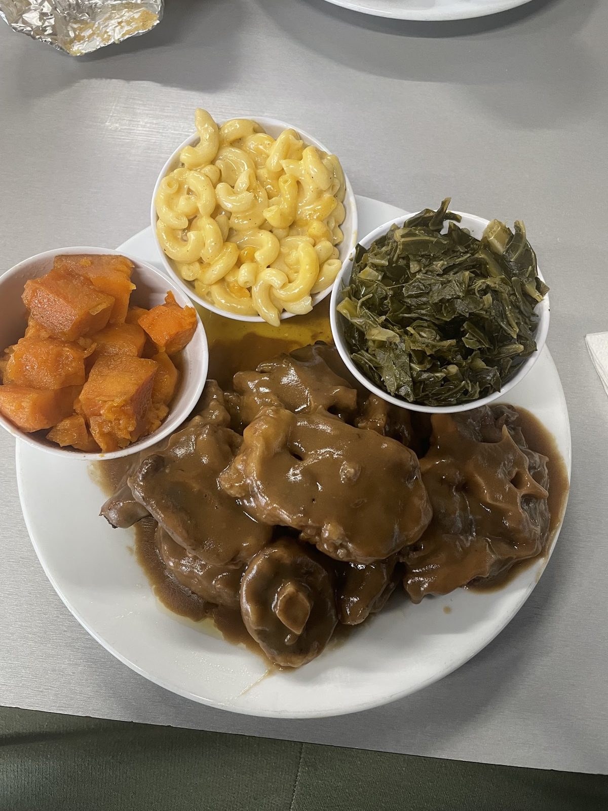 Smothered turkey wing with mac & cheese, greens and yams